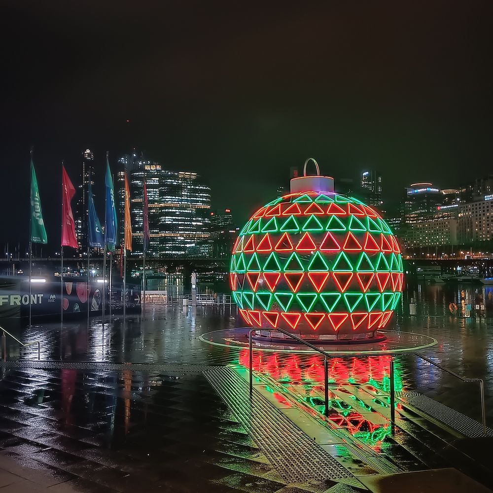 Ein gigantischer Weihnachtskugel auf dem Boden posiert.
