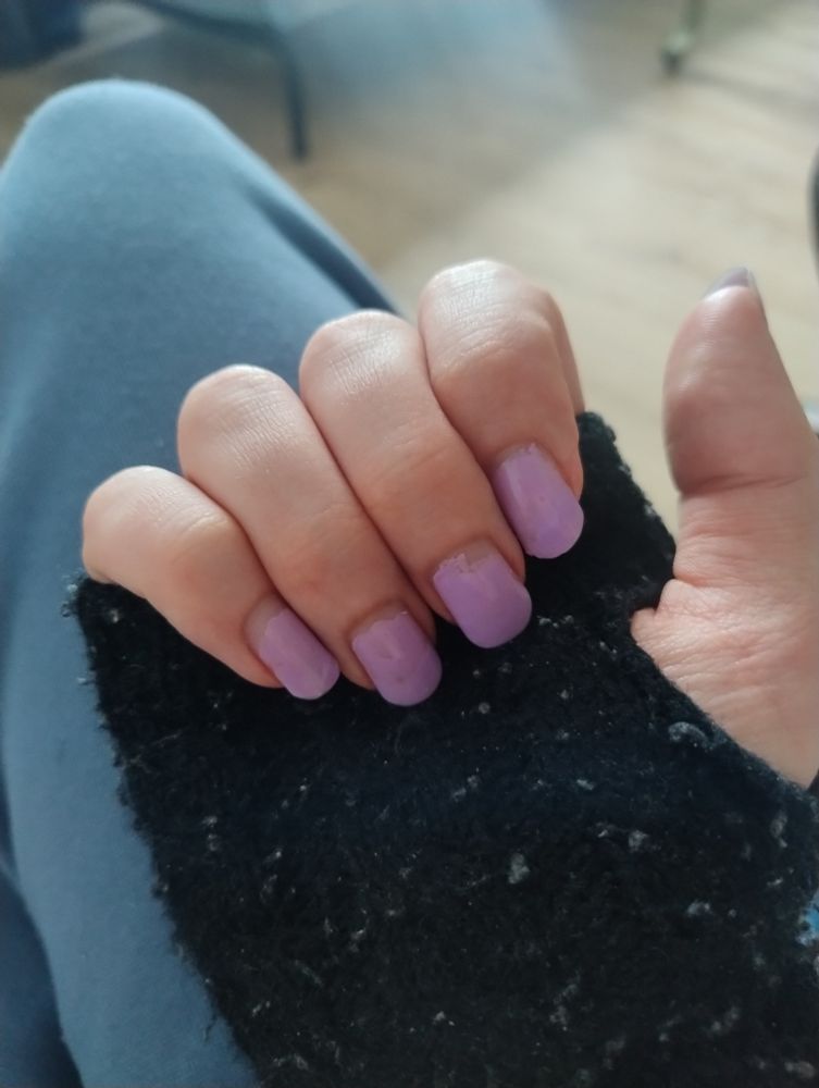 my hand on my leg with lavender nail polish in black half gloves 