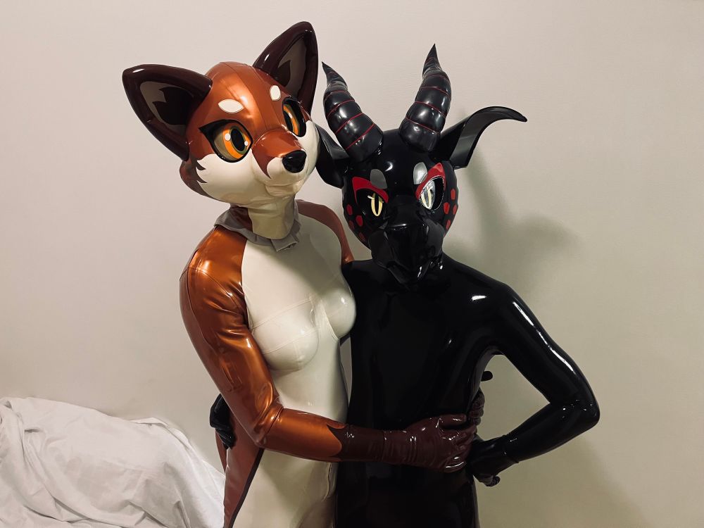 Latex vixen and latex dragon holding each other 