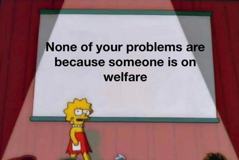 The image is of Lisa Simpson on a stage with a projector behind her saying “ none of your problems are because Someone is on a welfare” 