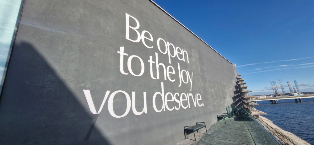 Inscription on a museum wall: 'Be open to the joy you deserve.' 