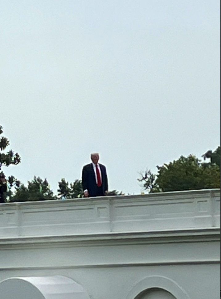 A deranged elderly man (Donald Trump) standing on the roof of the White House in the middle of the day.