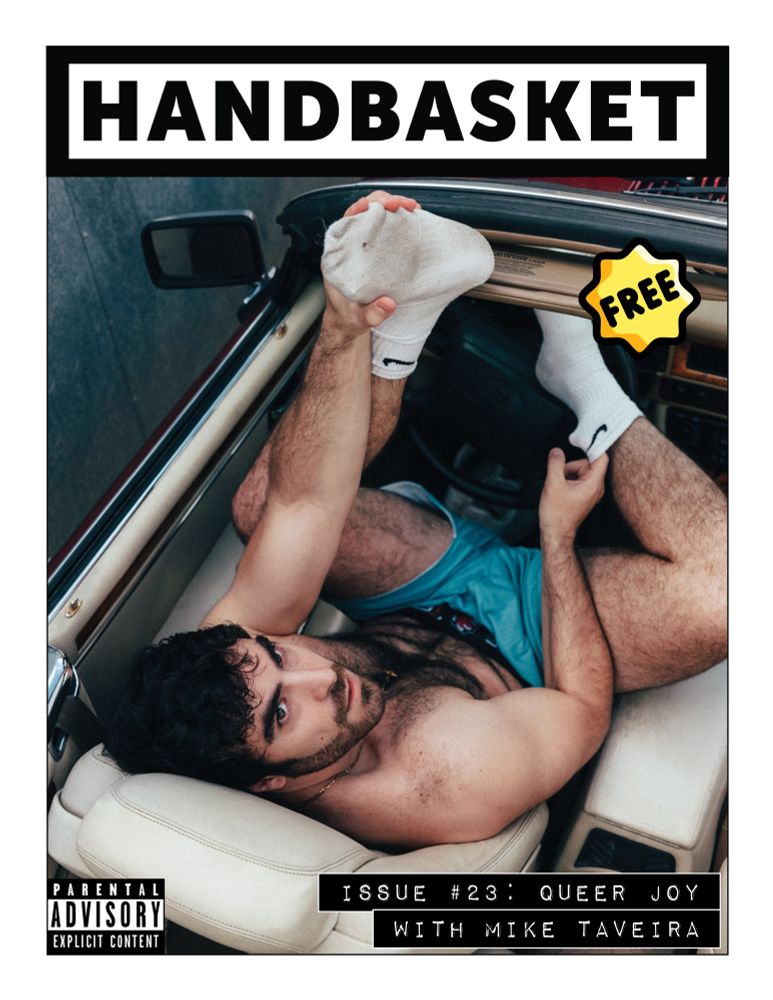 As seen from above, Mike Taveira sits in the driver’s seat of a convertible wearing only teal shorts and dirty white socks. He’s looking up and toward the camera.