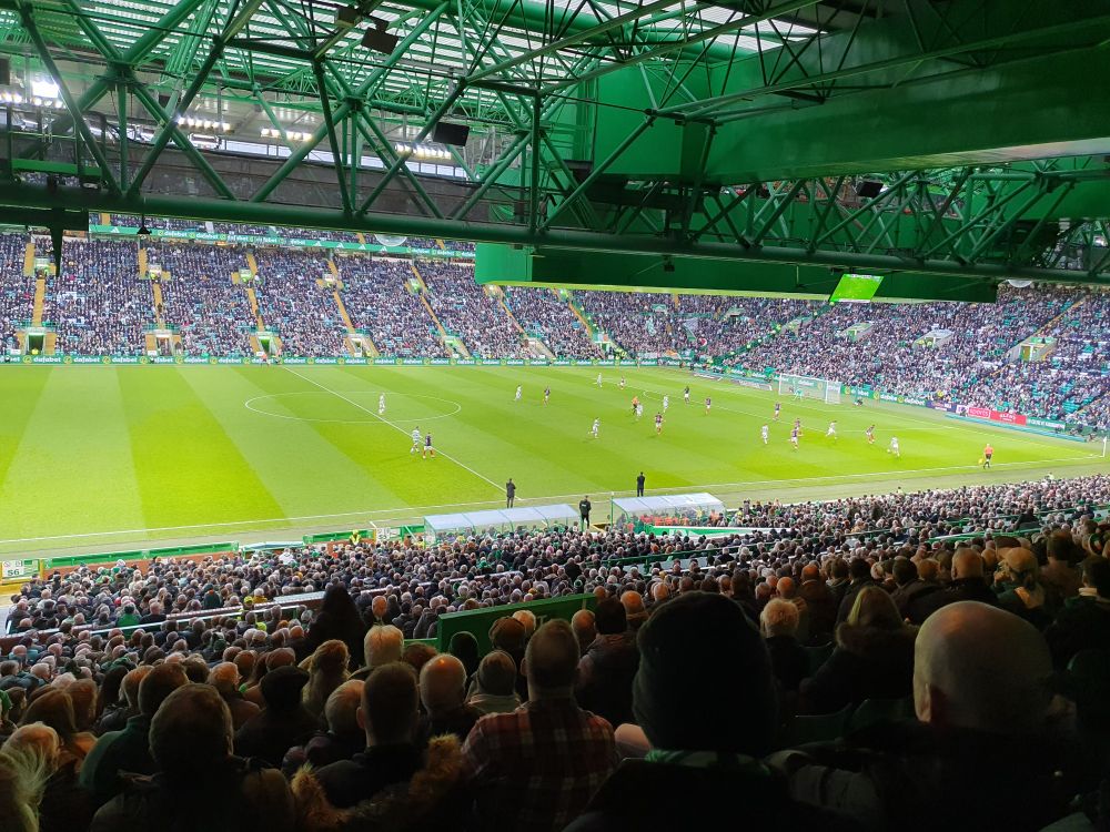 View of the pitch from back of the main stand Celtic Park looking over the heads of the crowd during a game.