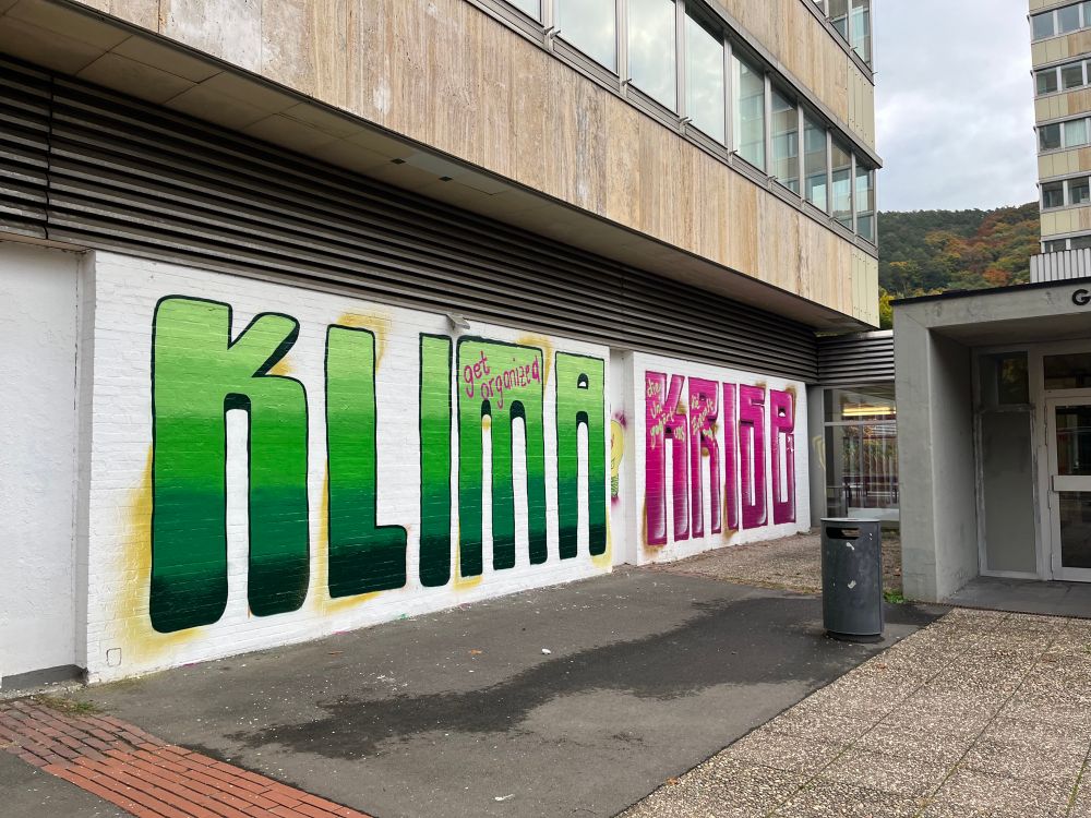 graffiti schriftzug klima krise in pink und grün 