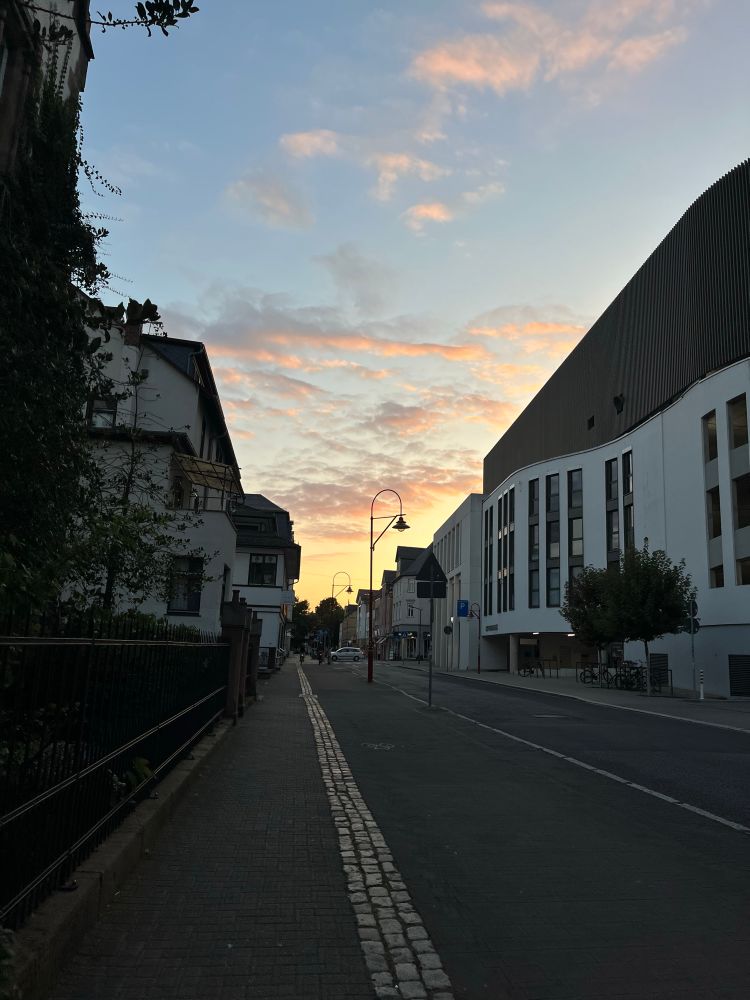 straßenansicht marburg mit sonnenuntergang in gelb orange rosa, himmlische stimmung