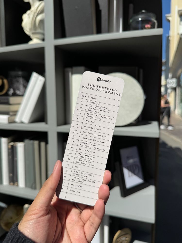 A tortured poets department bookmark with the tracklist 