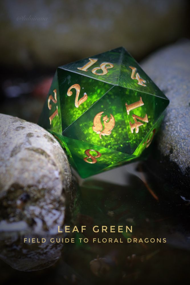Green liquid core d20 with gold numbers next to rocks in water