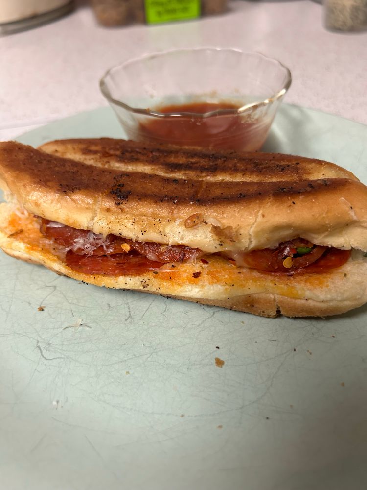 A grilled pizza sandwich on a plate