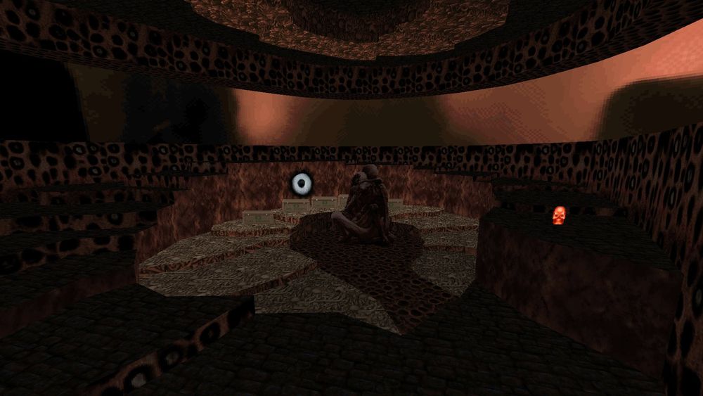 A brown room, dark and ominous. Some kind of big statue/ornament in the middle. Around it lighter colored tiles, and again around that dark, brooding stairs. 

An eye seems to stare at eyes from the very walls itself!