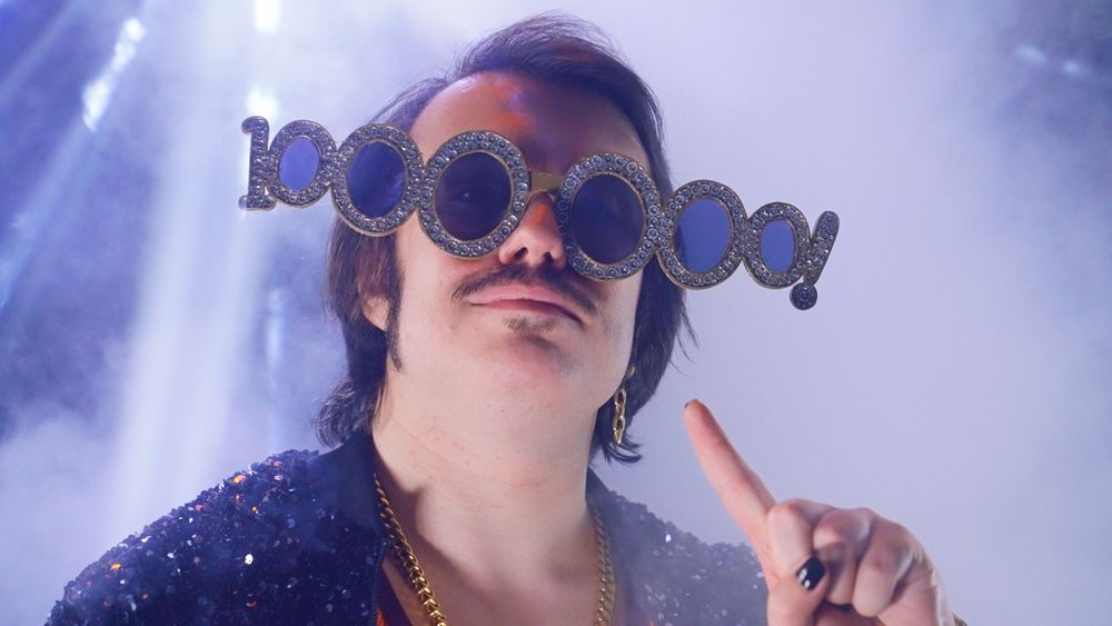 Stupendium wearing big sparkly glasses that read '1,000,000!'