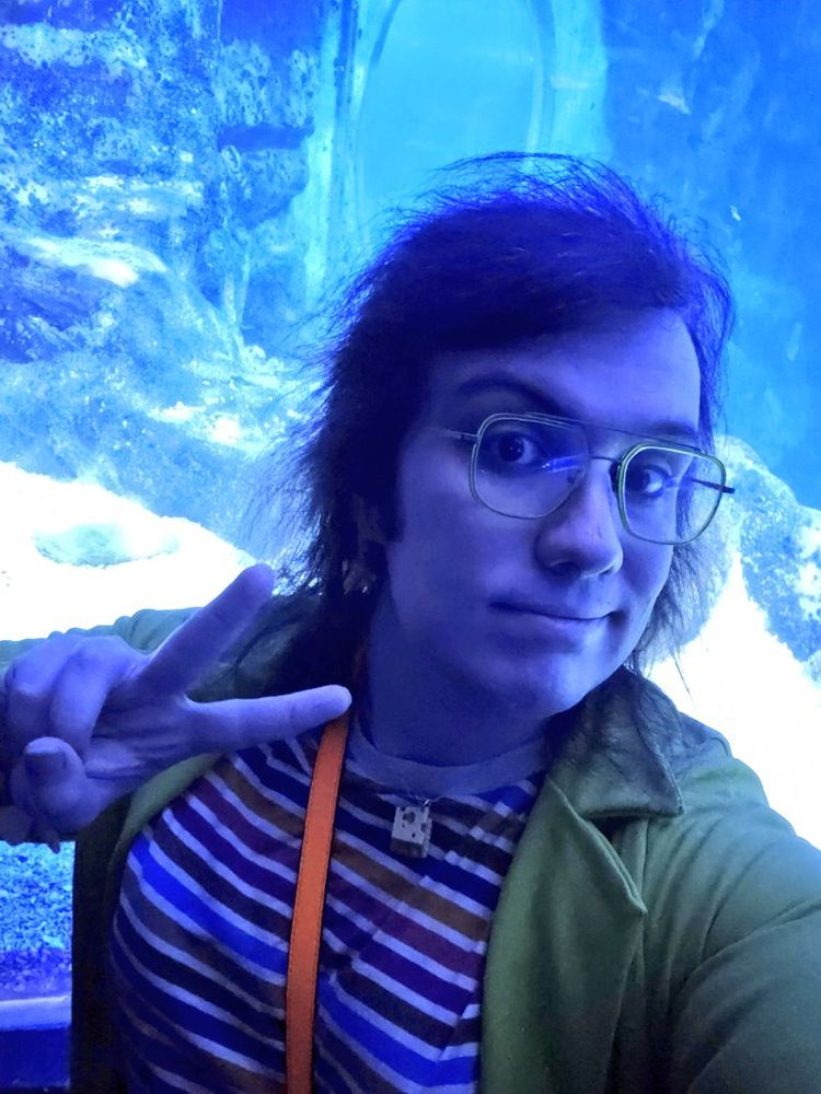 As before but now they are stood in front of a giant fish tank.