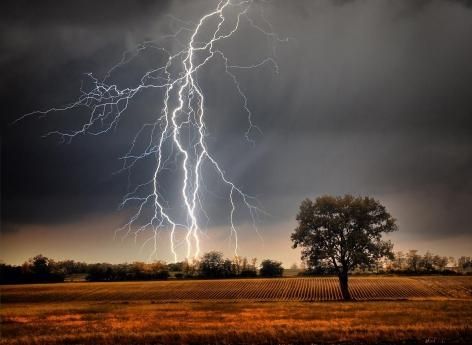 Éclairs impressionnants tombant au loin sur une prairie, symbolisant l'attaque de panique 