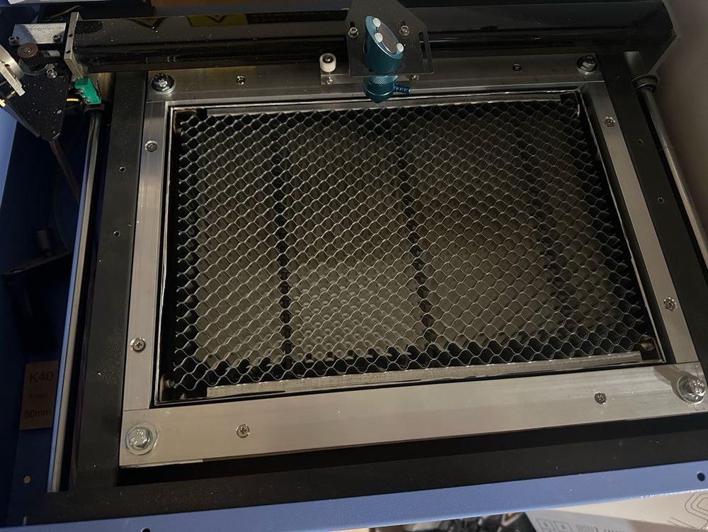 The interior of a CO2 laser cutter machine, showing a home-made z-axis table for adjusting the focus of the beam. 