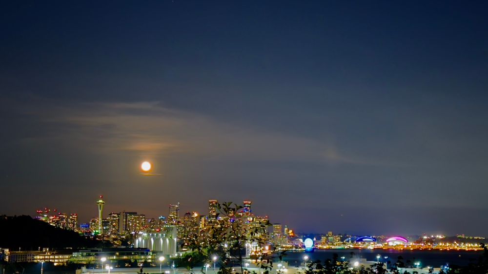 📸James Wright: Seattle skyline with Moon, Space Needle, Ferris wheel, and stadiums among other buildings in view. 09 Aug 2025, Seattle, WA. 