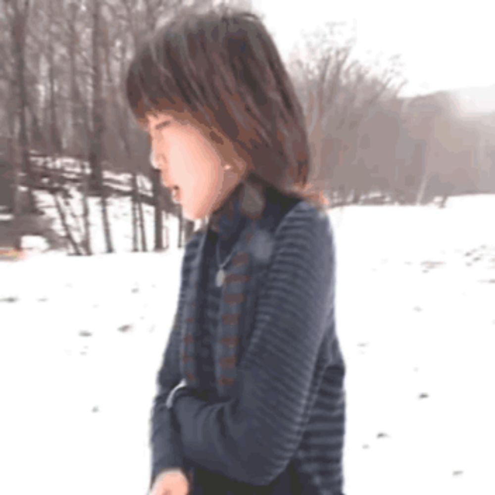 a woman in a striped sweater is standing in the snow