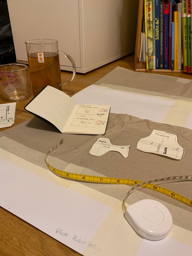 Foto eines Maßband, Schnittmuster Dummy und zusammengeklebtes Papier