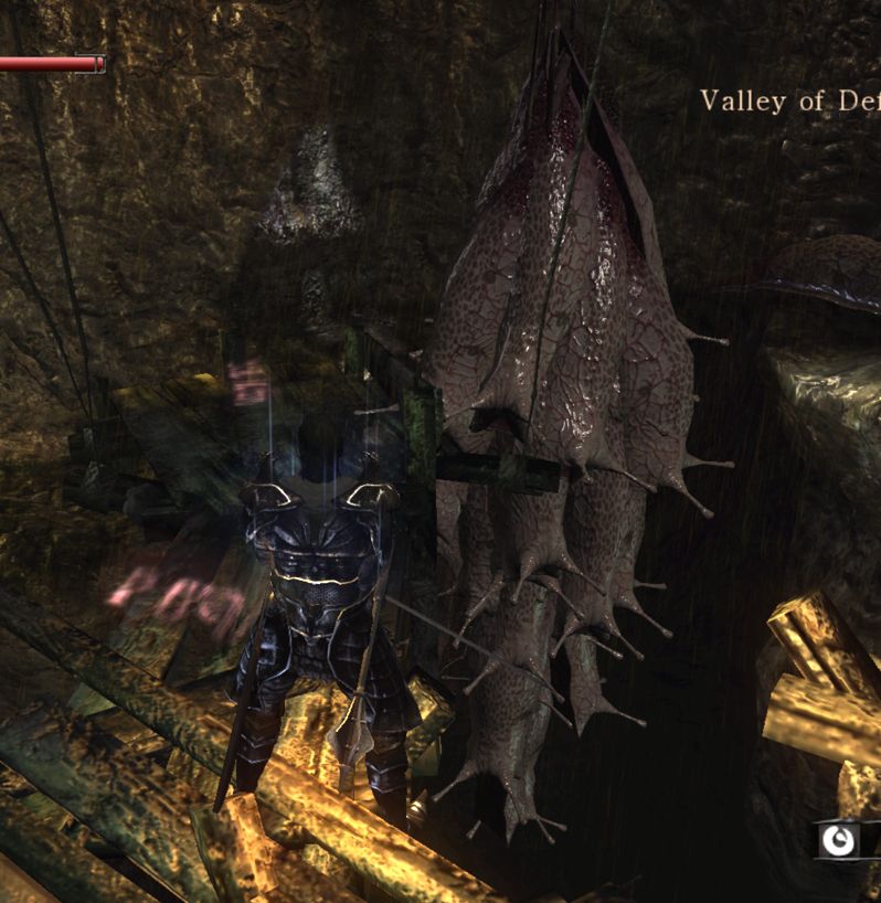 screenshot from Demon's Souls, a player character stands in front of a bunch of slugs that are all hanging from the ceiling in a pile