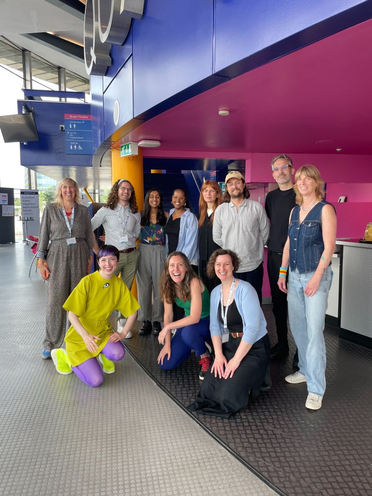 BRAID-commissioned artists gathered at the Lowry, smiling and with bright colours in the background.