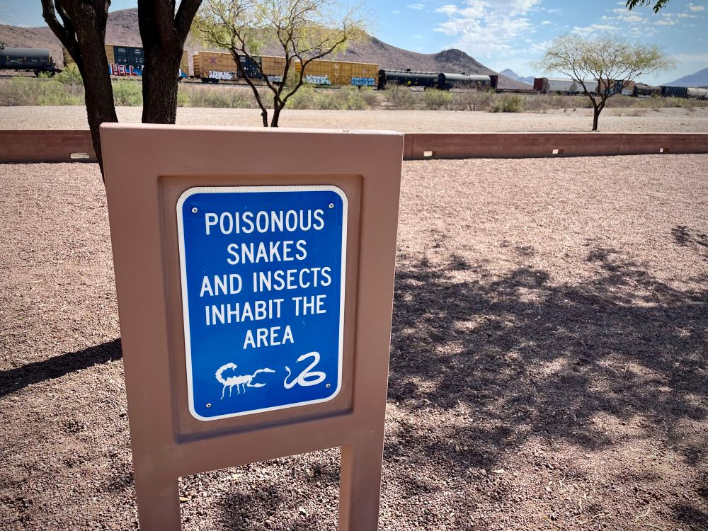 A sign in an Arizona rest stop that reads, Poisonous snakes and insects inhabit the area.’