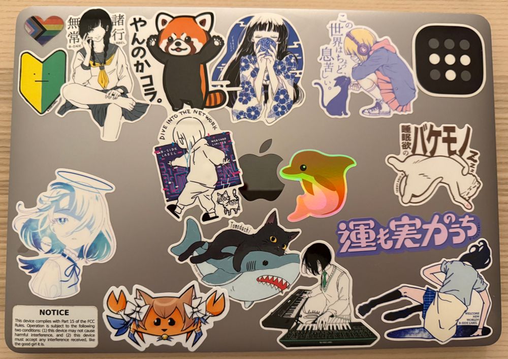 macbook with 17 stickers on it mostly of cute animals and girls