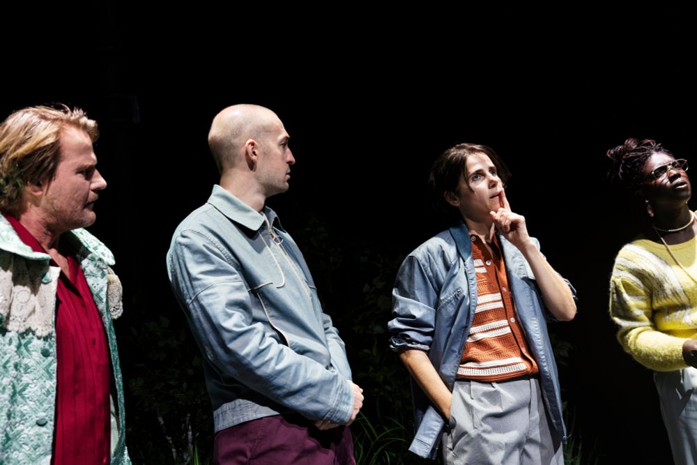 Szenenfoto mit vier Personen in bunten 80er-Jahre Kostümen nebeneinander stehend