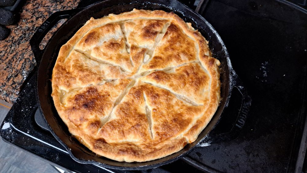 A top crust-only apple pie in a cast iron skillet