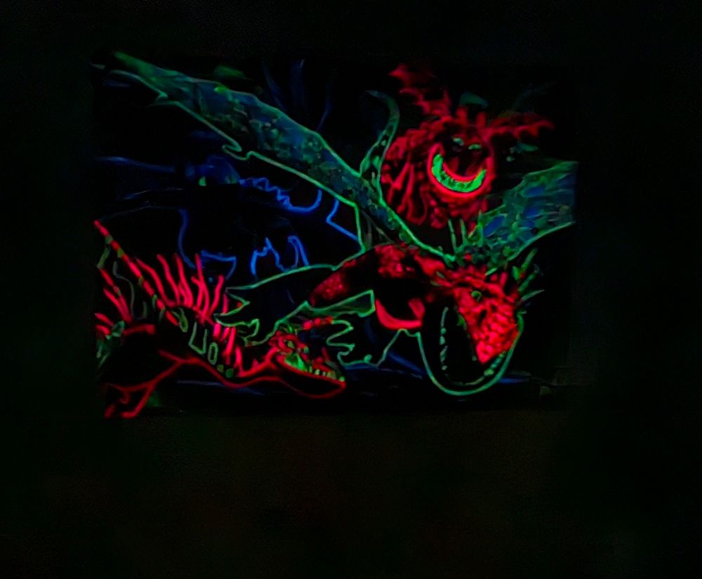 "Drachenzähmen leicht gemacht" Puzzle mit 4 in rot, grün und blau leuchtenden Drachen im dunklen Zimmer