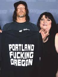 daryl dixon from the walking dead actor holding a t-shirt that says PORTLAND FUCKING OREGON like they used to sell at the roxy and i think the woman with him owned the roxy? not sure 