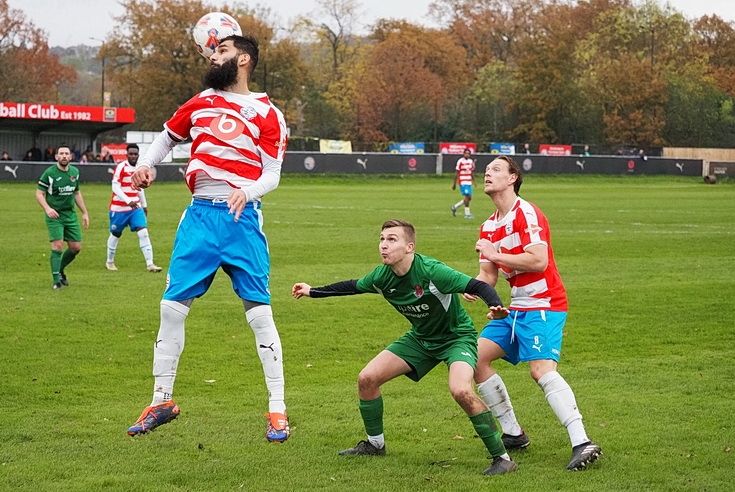 Captain Nicky Meta gets his head to the ball as Jacob Kemp looks on.