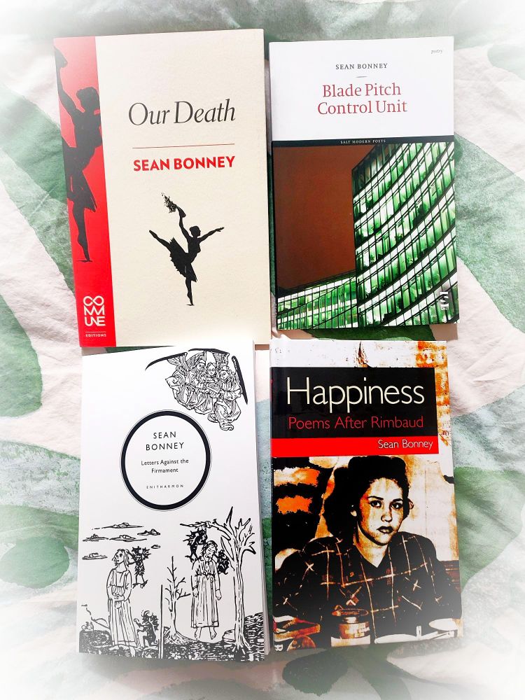 4 Sean Bonney books - top lhs Red and white cover of Our Death with silhouette of dancer, top rhs Blade Pitch Control Unit with lit office building, bottom lhs letters against the firmament with black and white illustrations, bottom rhs Happiness (Poems After Rimbaud) black and red cover with photo of young woman in black and white on the cover.