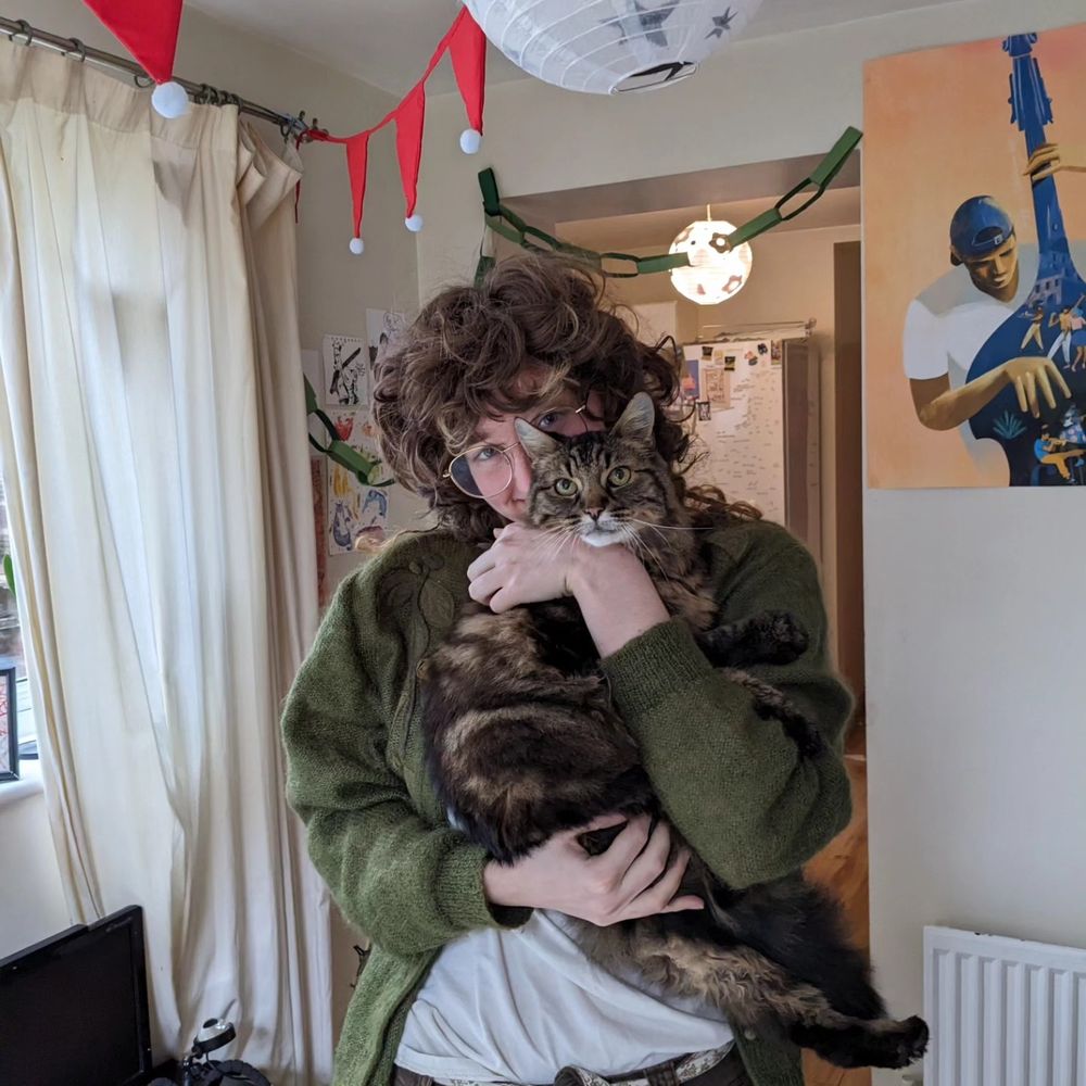 auri also known as beetlebug (my husband) holding a very fluffy cat