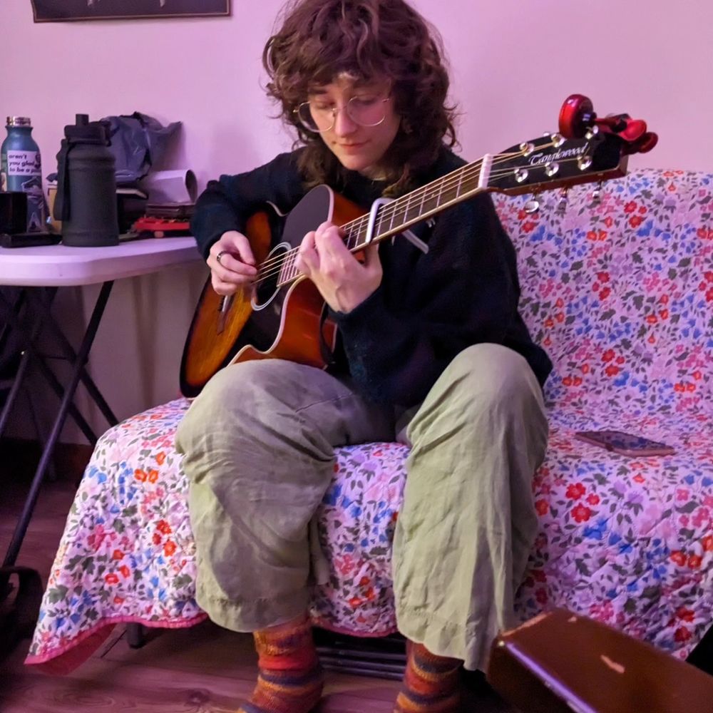 auri playing guitar in my living room