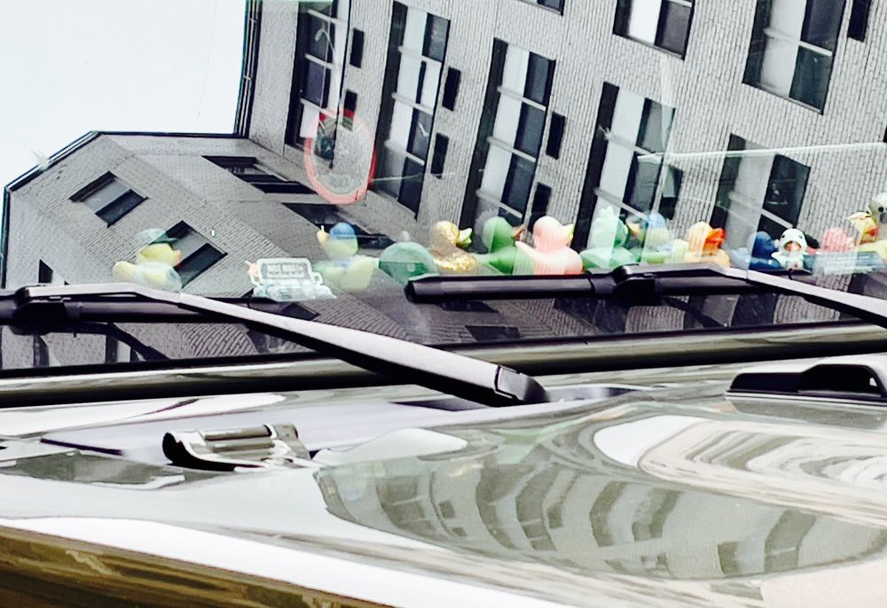Sideways reflection of building in vehicle windshield 