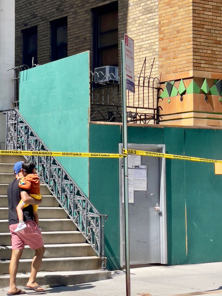 Man carrying child on a NYC street on a sunny day