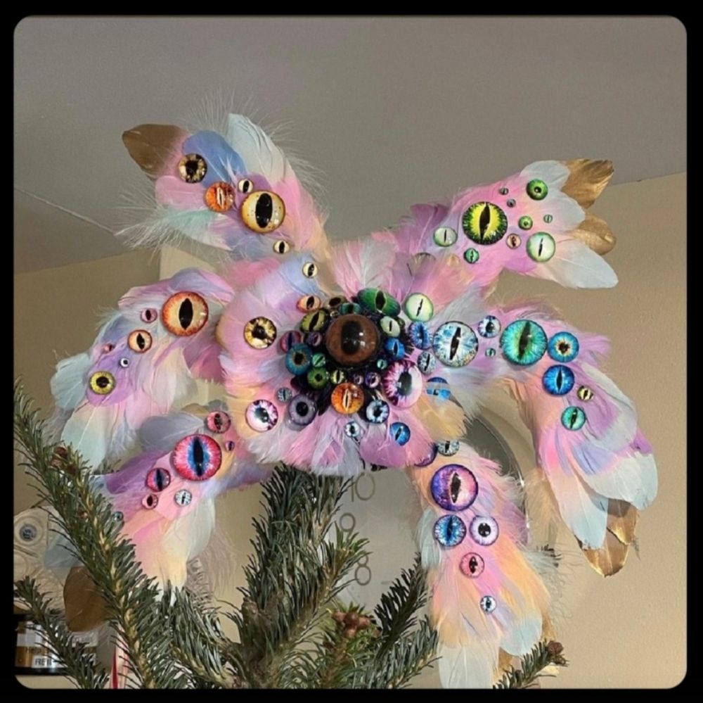 Adorno de arcángel bíblicamente correcto, con 3 pares de alas y miles de ojos, sobre la punta de un árbol navideño.