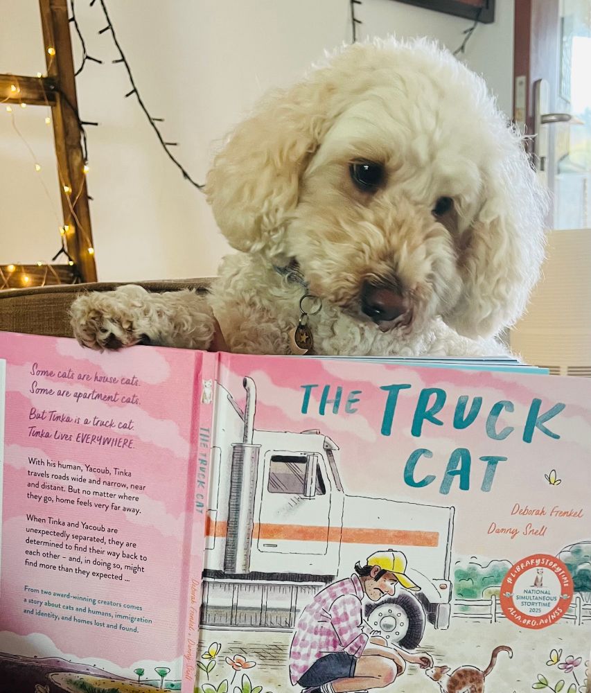 Fluffy cream dog reading The Truck Cat