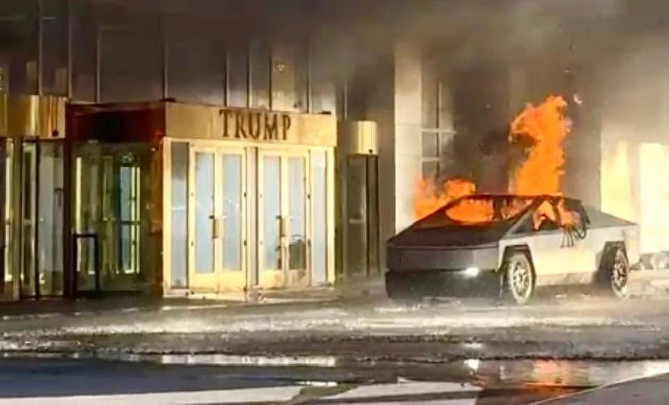 A cybertruck burns next to the entrance of a Trump building. 