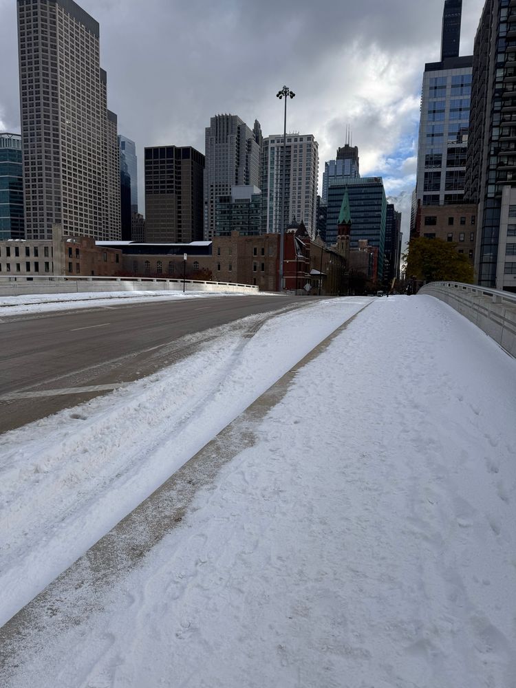 Adams Street Bridge into the Loop. The car lanes are perfectly clear while the sidewalks and shoulders are covered in snow