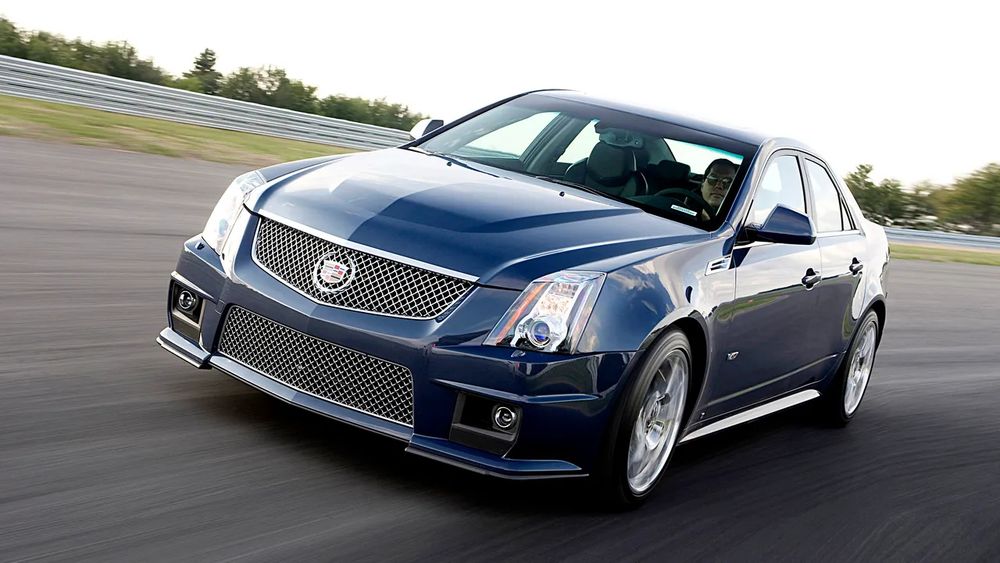 picture of a dark colored cadillac sport sedan on a track