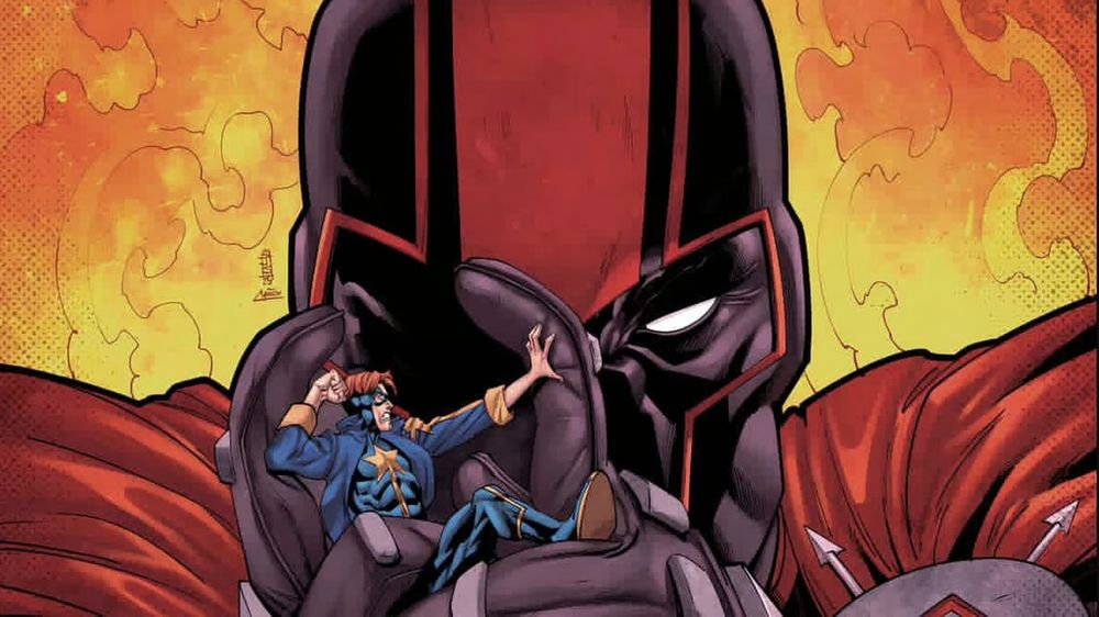 A masked supervillain (The Spartan) holds a tiny superhero (Allstar) in between his fingers as if to crush him. Yellow and orange fire is behind the supervillain, who is dressed in a red cape and black mask with a red stripe down the center of his forehead. The Superhero is in Blue and yellow uniform with a star in the middle of his chest.