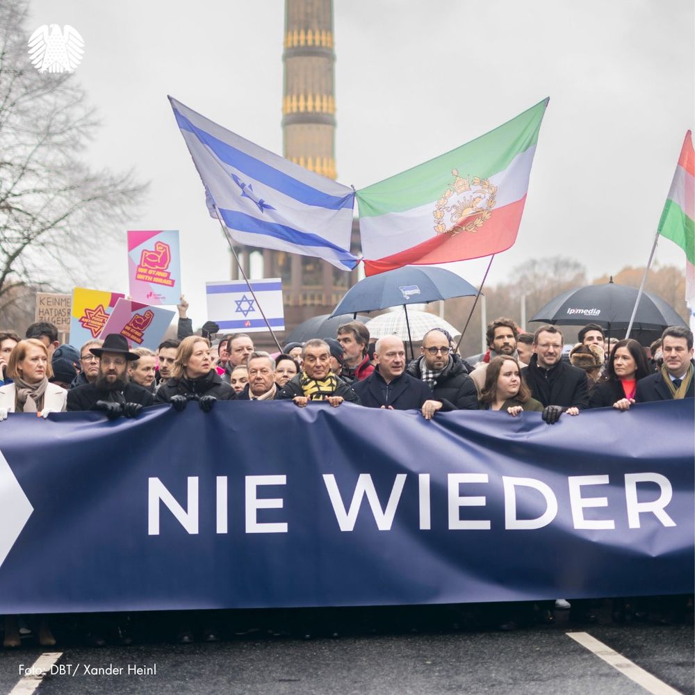 Bundestagspräsidentin Bas hält gemeinsam mit anderen prominenten Teilnehmerinnen und Teilnehmern der Solidaritätsveranstaltung ein Banner mit der Aufschrift "Nie wieder (ist jetzt!)" in den Händen. Zu sehen sind u.a. die Bundesminister Paus und Heil, Rabbi Teichtal, Roland Kaiser, Kai Wegner und Ricarda Lang.