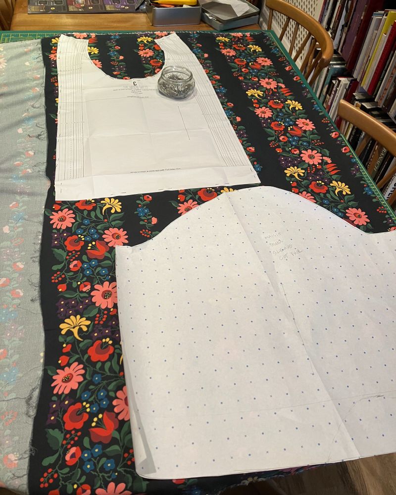 Pattern pieces laid out on a navy fabric with colourful floral stripes.