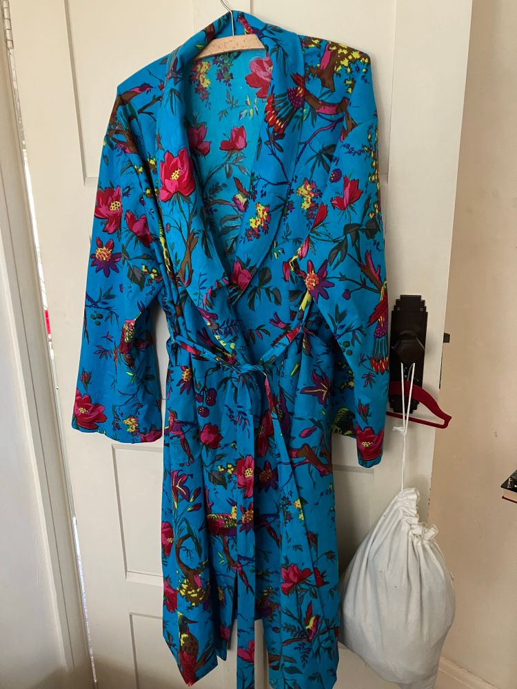 A cotton dressing made of Indian woodblock fabric is vibrant blue with colourful birds and flowers. 