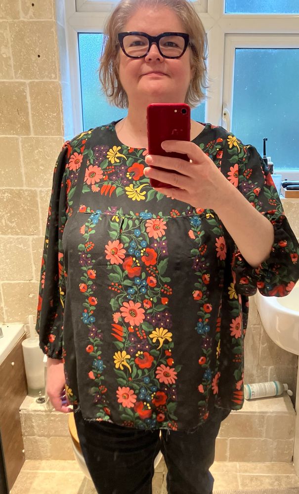 A 50-something fat white woman smiles as she models her new blouse.