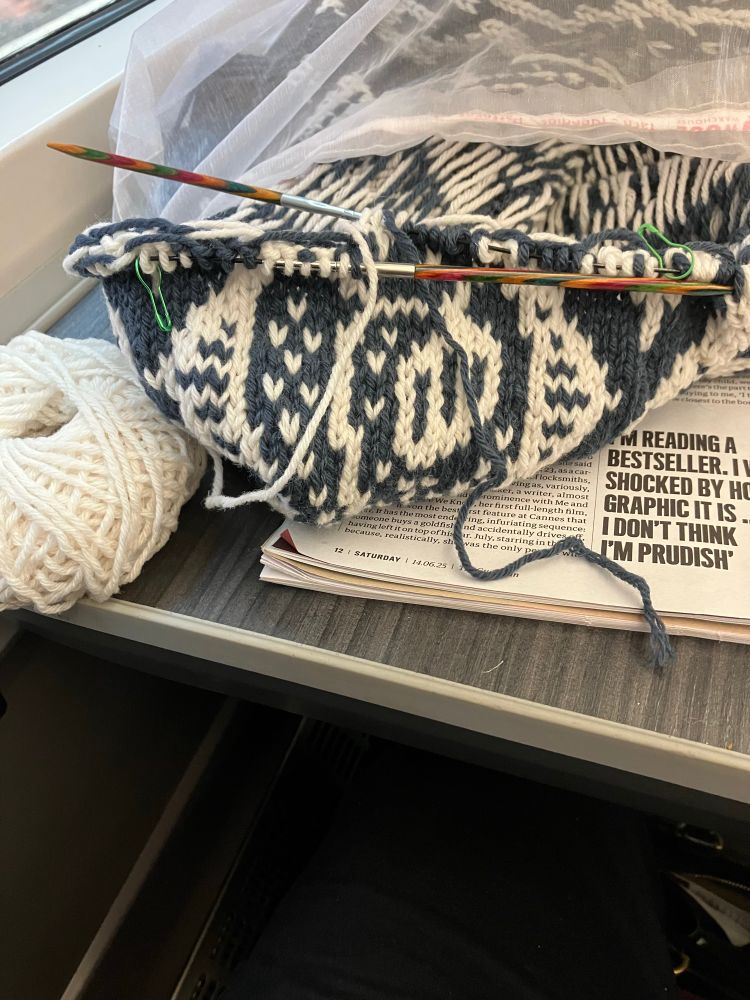 A partly knitted sweater in blue and white wool. Only 20cm of blue wool remain. 