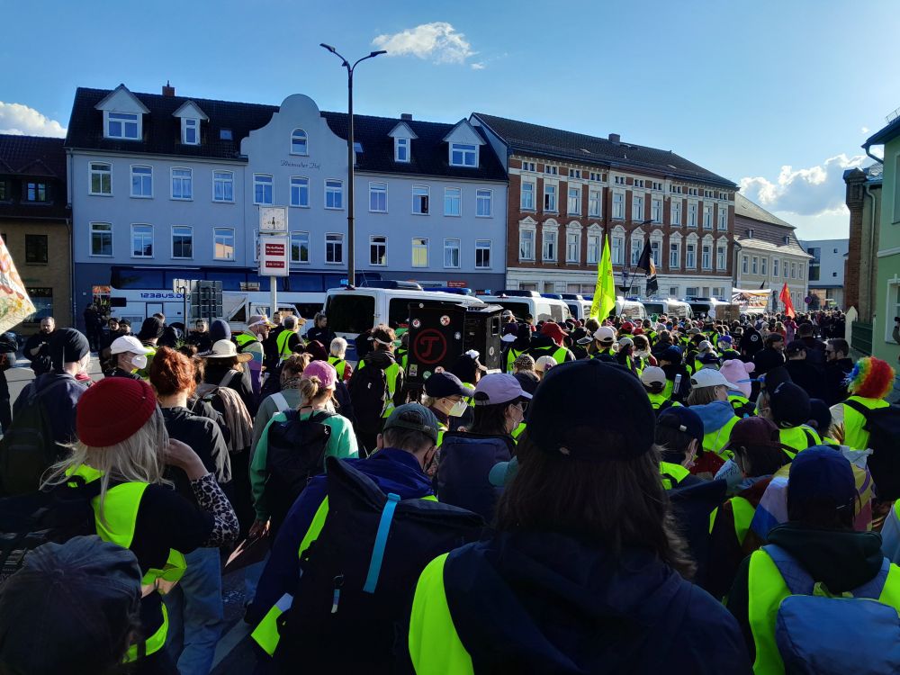 Viele Menschen, Fahnen, gelbe Westen -
Im Hintergrund Polizeiautos