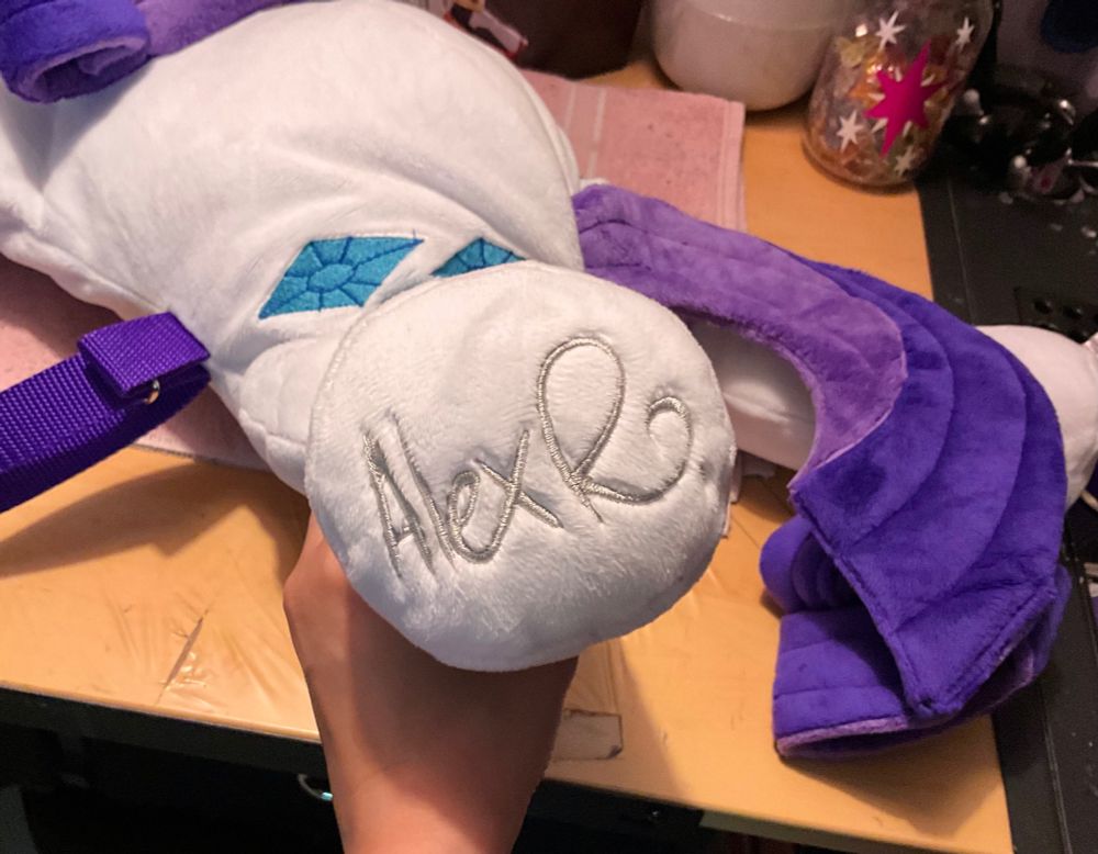 A view of the bottom of the backpack's hoof, where the signature Alex R. is embroidered in silver.