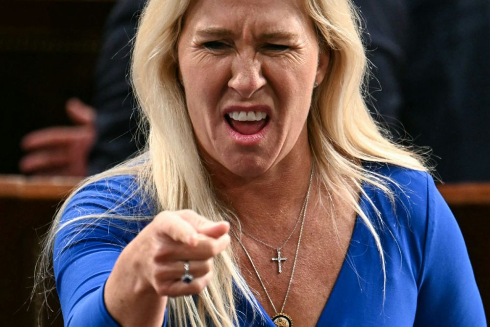 picture of an angry, sneering MTG pointing her finger at town hall participants, from spring of 2025