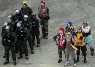 portland ICE protesters dressed in clown/riot gear face off against ICE next to portland riot police.